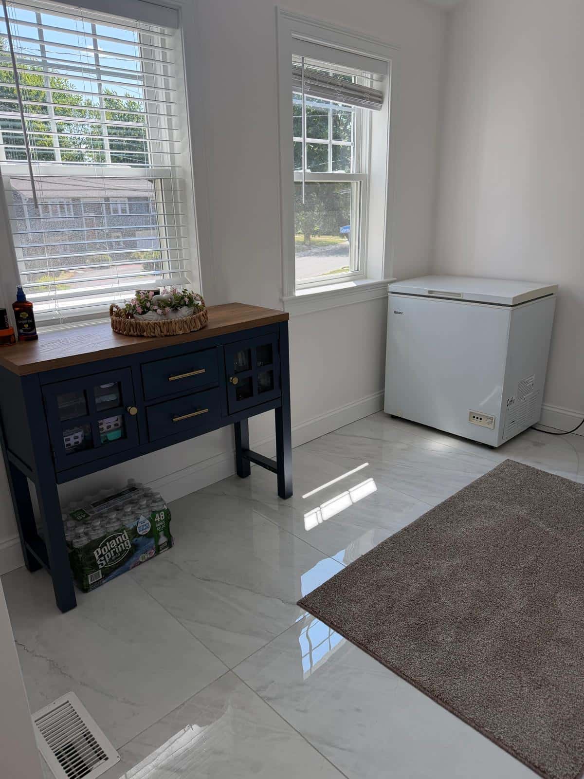 Entryway with polished marble tile floor and a console table after cleaning